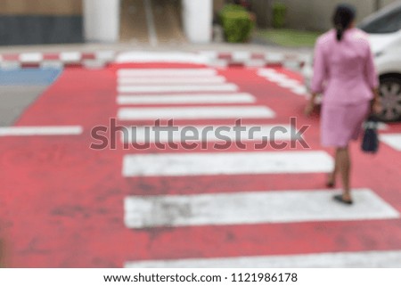 Blurred of People walking on a red crosswalk