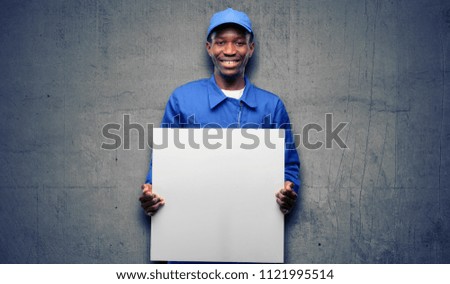 African black plumber man holding blank advertising banner, good poster for ad, offer or announcement, big paper billboard