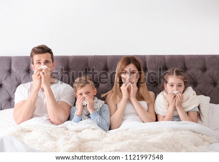 Family suffering from cold in bed at home Royalty-Free Stock Photo #1121997548