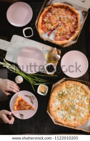 Pizza set on wooden table with bright plates for party. Dark rustic toning food photo. Top view image.
