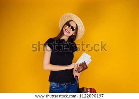 an attractive confident girl in a straw hat and sunglasses goes on vacation, keeps plane tickets