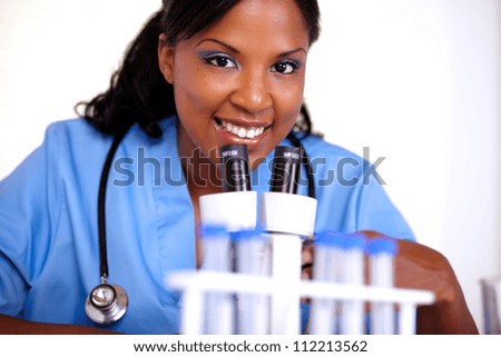 Medical doctor woman looking at you in blue uniform with a stethoscope at laboratory