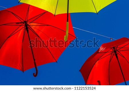 Colourful umbrellas urban street decoration. Hanging colorful umbrellas over blue sky, tourist attraction, sunny day
