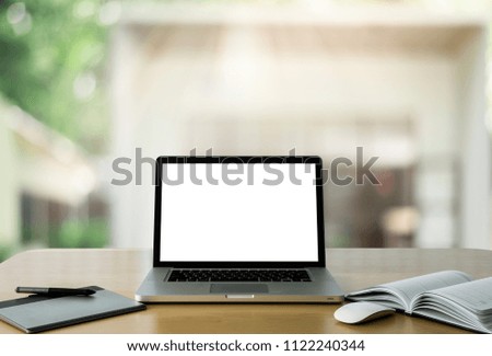 Workspace wood desk with Laptop with blank screen and wireless mouse and graphics tablet and notebook at home blurred background at light bokeh.