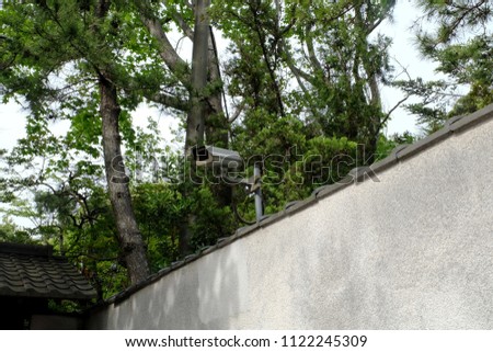 CCTV Camera on grey concrete wall. CCTV security camera for home protection, privacy, security against crime & surveillance. Closed circuit camera on gray wall background.
