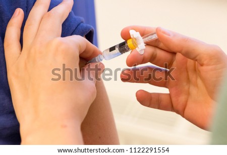 Doctor vaccinating a young woman - Immunisation against diseases Royalty-Free Stock Photo #1122291554