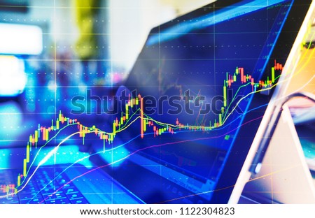 Computer screen with selective focus of technical price graph and indicator, red and green candlestick chart, market volatility, up and down trend. Stock trading, crypto currency background. Royalty-Free Stock Photo #1122304823