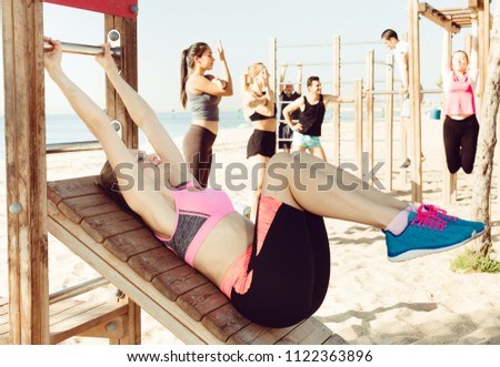 Focusing woman doing workout on beach in sunny morning