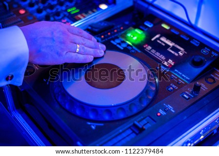 Close view on the hands of dj playing the mixer