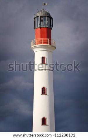 White lighthouse over dramatic cloudy sky