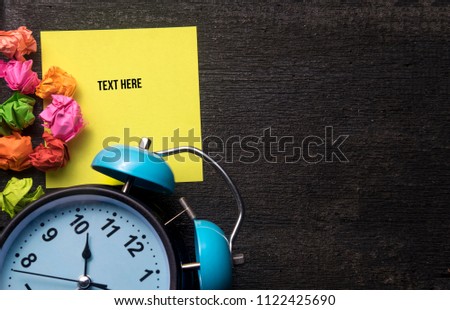 Creative layout made of colourful paper and retro clock with yellow note. Flat lay. Copy space for text.