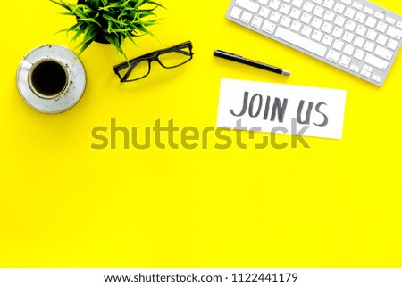 Template for contacts. Hand lettering Join us on work desk with glasses, coffe, plant, computer keyboard on yellow background top view copy space