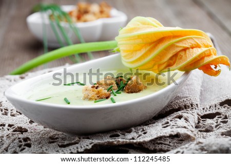 Bowl of zucchini soup with croutons and chives