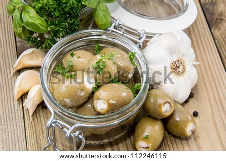 Pickled Olives in a glass on wooden background