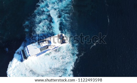 Aerial drone bird's eye view photo of high speed cruise boat in deep blue mediterranean sea