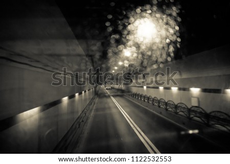 Dark tunnel car at night, traveling on target in black and white tone.