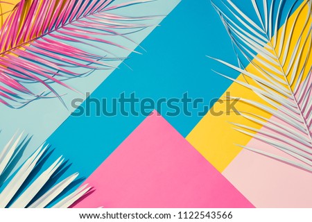 Tropical bright colorful background with exotic painted tropical palm leaves. Minimal fashion summer concept. Flat lay. Royalty-Free Stock Photo #1122543566