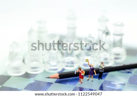 Miniature people : Businessman reading a book with pencil and Chess,Education Business concept.