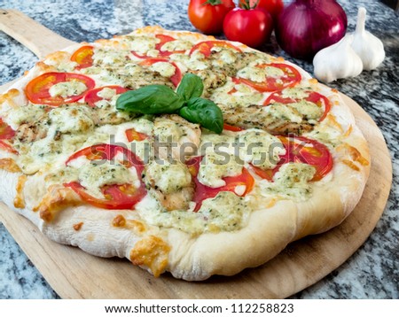 Chicken Pesto and Tomato Pizza: A whole gourmet chicken pesto pizza with fresh tomatoes and basil