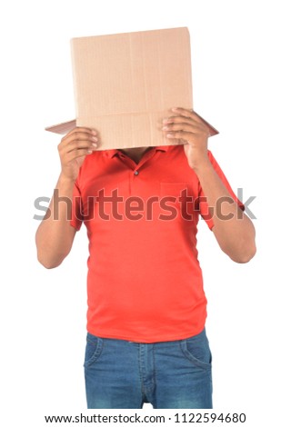 Young man gesturing with a cardboard box on his head isolated on white background