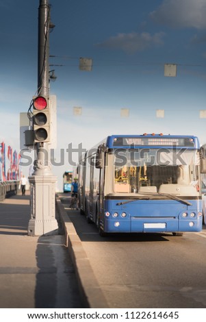 Blue Bus on the road in city near the Kremlin at Bolshoy Kamenny Bridge. Red traffic light.