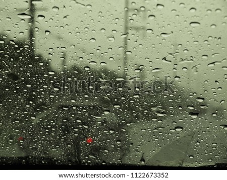 Driving in rain,Blured background with rains drop on glass and cars on the road.