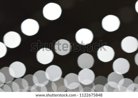 Many white blurred circle bokeh on black background.