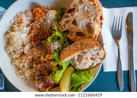 Traditional Icelandic grilled red fish, rice and salad, summer time, indoor