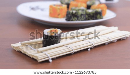 sushi rolls and chopsticks on a wooden table