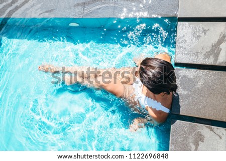 Woman sits in swimming pool