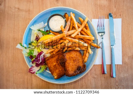 Traditional Icelandic grilled fish and chips, and salad, summer time, indoor