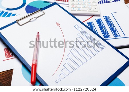 Top view of business paper chart or graph on wooden table