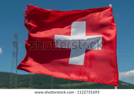 Swiss flag moving in wind on blue sky 
