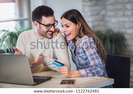 Smiling couple using digital tablet and credit card at home Royalty-Free Stock Photo #1122762485