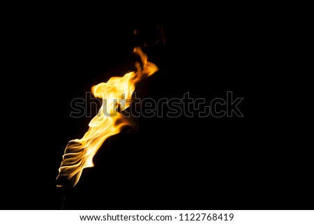 flame of a torch in the dark on a black background, only the fire is visible Royalty-Free Stock Photo #1122768419