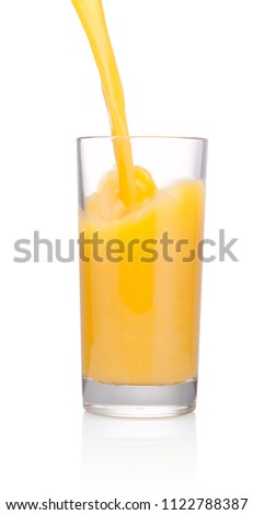 Orange juice is pouring into glass isolated on white background