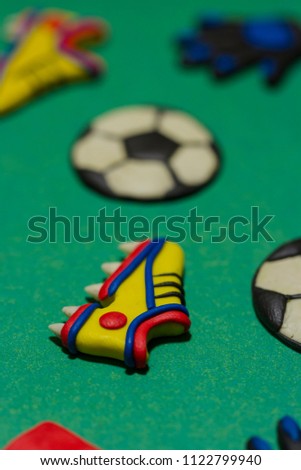 Yellow sneakers and soccer ball. Children's football. Colorful plasticine picture