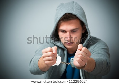 Arrested teenager with handcuffs on his hands Royalty-Free Stock Photo #112286024