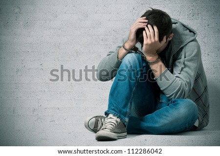 Arrested teenager with handcuffs on his hands Royalty-Free Stock Photo #112286042