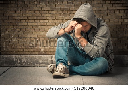 Arrested teenager with handcuffs on his hands Royalty-Free Stock Photo #112286048