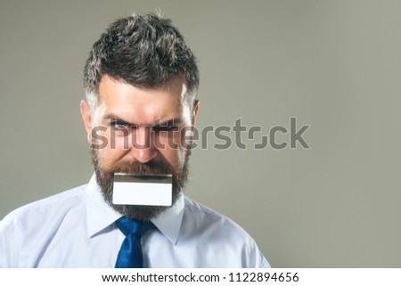 Banking services. Internet banking money credit card. Bearded man with card in teeth, businessman with payment finance card with magstripe. Credit card to fund your business. Financier with creditcard
