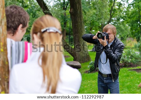 Photographer takes picture of young couple outdoors