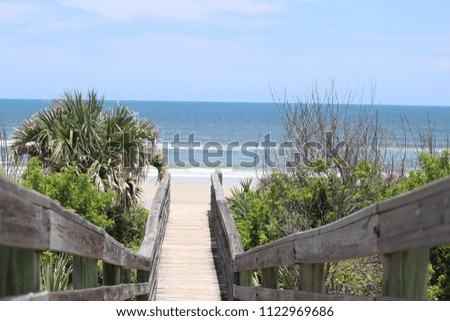 Beach walk-over access wooden steps path boardwalk perspective photography of blue water, sky, horizon.