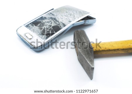 broken cell phone with a hammer on a white background