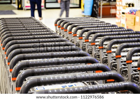 Shopping Cart In Supermarket, Japan. Many Empty Shopping Carts In A Row. Inside A Large Supermarket. Image For Banners, Presentations,Wallpaper. Japanese Text Meaning Shopping Cart. CloseUp With Blur.