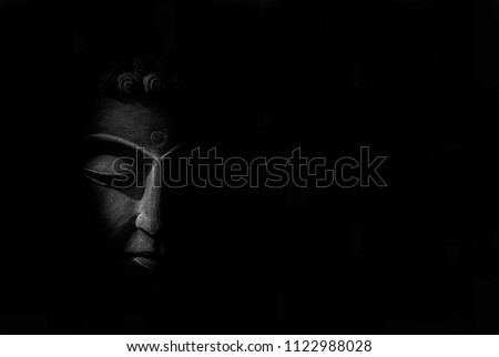 Black and white picture statue of Buddha Head made from sandstone carving with black left and right background