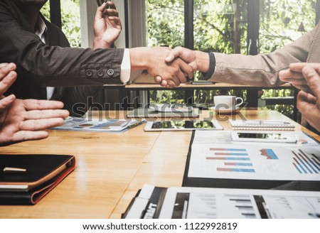 Shaking hands of business lawyer of tax and real estate broker after meeting in conference room, all people happy successfully.