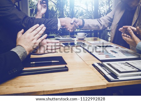 Shaking hands of business lawyer of tax and real estate broker after meeting in conference room, all people happy successfully. Royalty-Free Stock Photo #1122992828