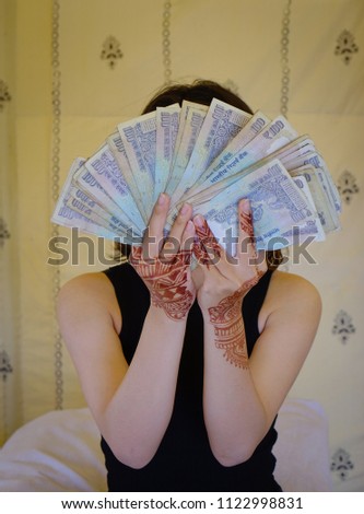 An India woman holding money on hands. Currency background.