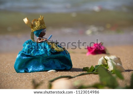 Picture Flowers on the beach sand and a doll representing iemanjá
